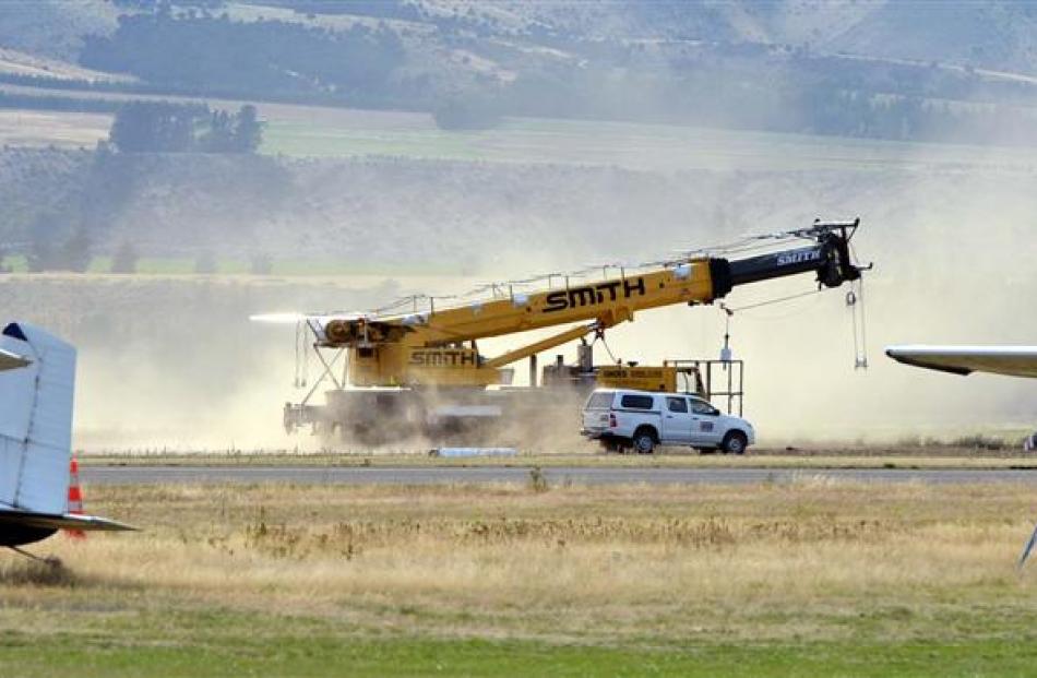 Dust billows behind a crane to be used in the Nasa balloon launch as it moves around the Wanaka...