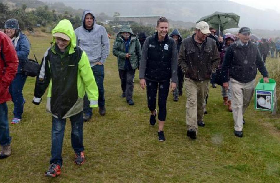 Doc staff and ecosanctuary members  brave the rain  to watch  Ben being placed into his new home.