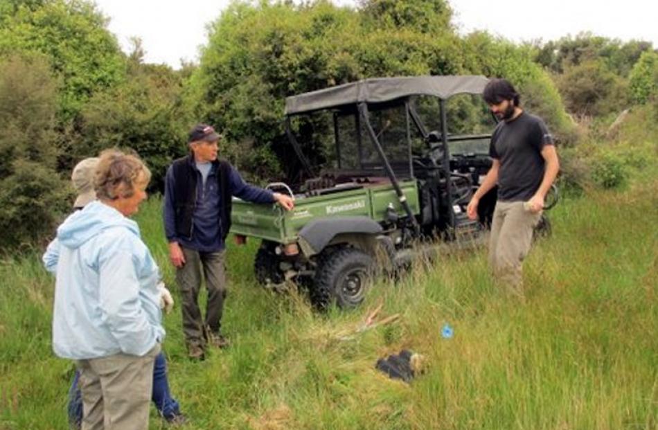 Volunteers discuss the placement of the first ''lizard hotel''. Photo by Alister Robinson