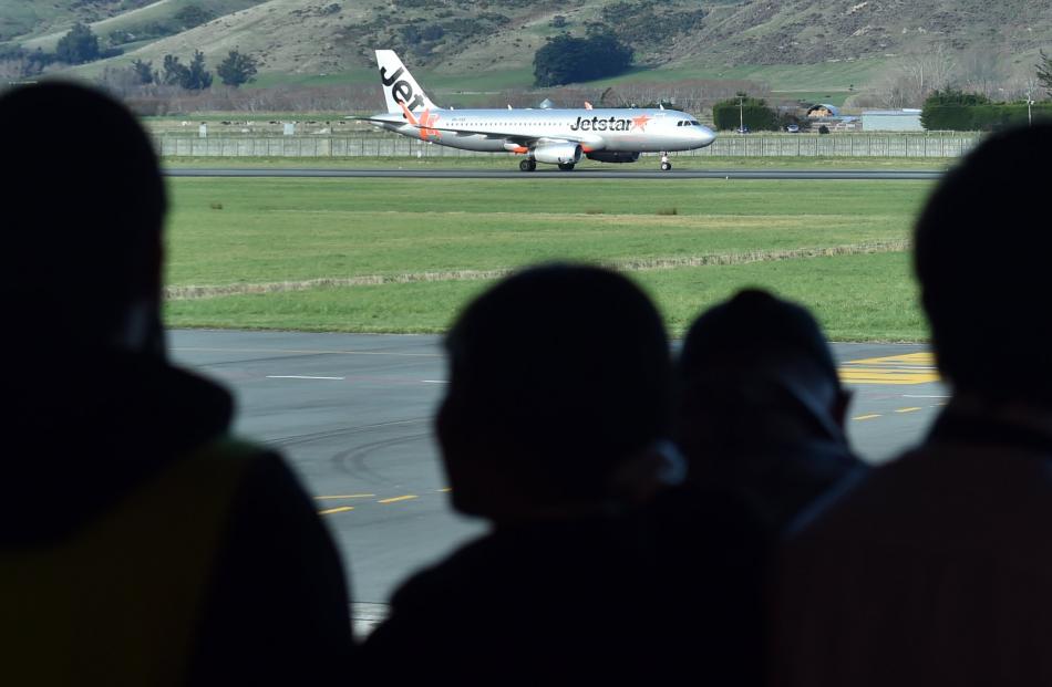 A crowd watch the first Jetstar flight from the Gold Coast to land at Dunedin Airport yesterday....