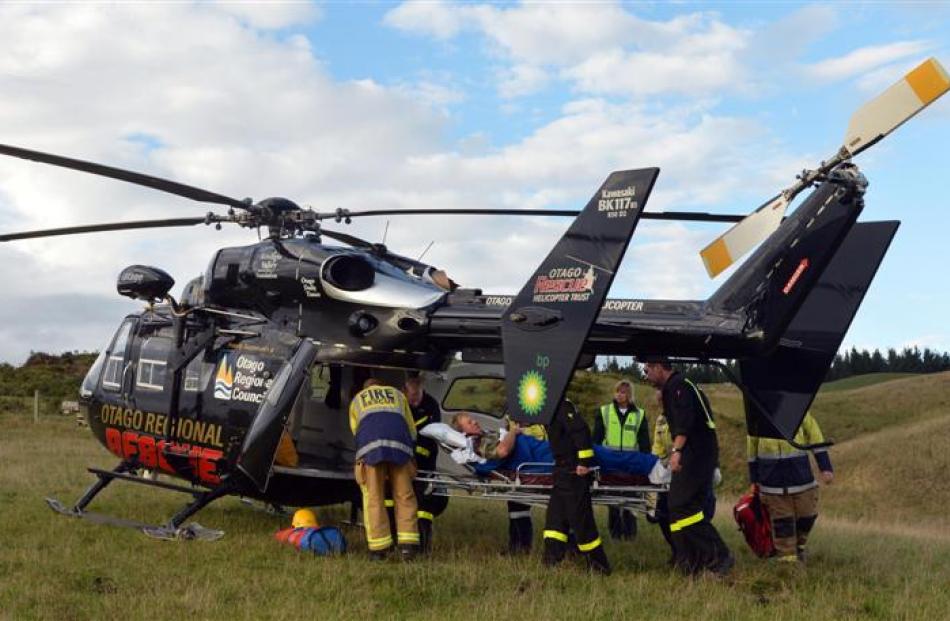 The injured farm worker is lifted into the helicopter, which landed in a paddock.