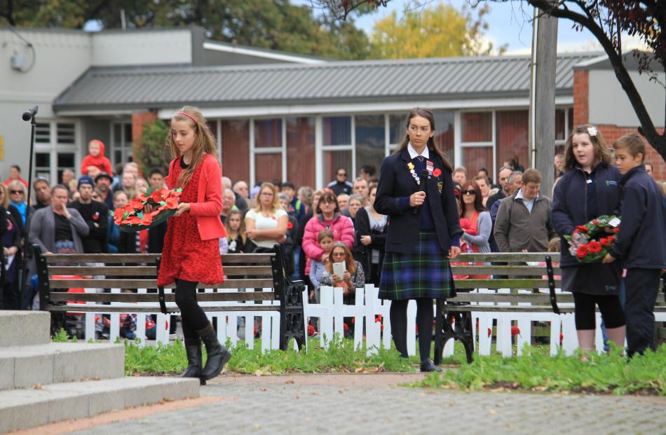 oe McElrea (9) lays a wreath at the Milton cenotaph for the Milton Public Library during Milton's...