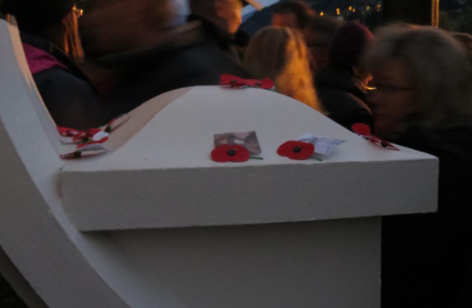 People pass by some of the poppies laid on the Queenstown Memorial Gates following the dawn...
