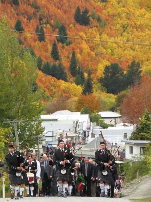 Pipers lead thousands of people from the Athenaeum Hall in Arrowtown to the war memorial.