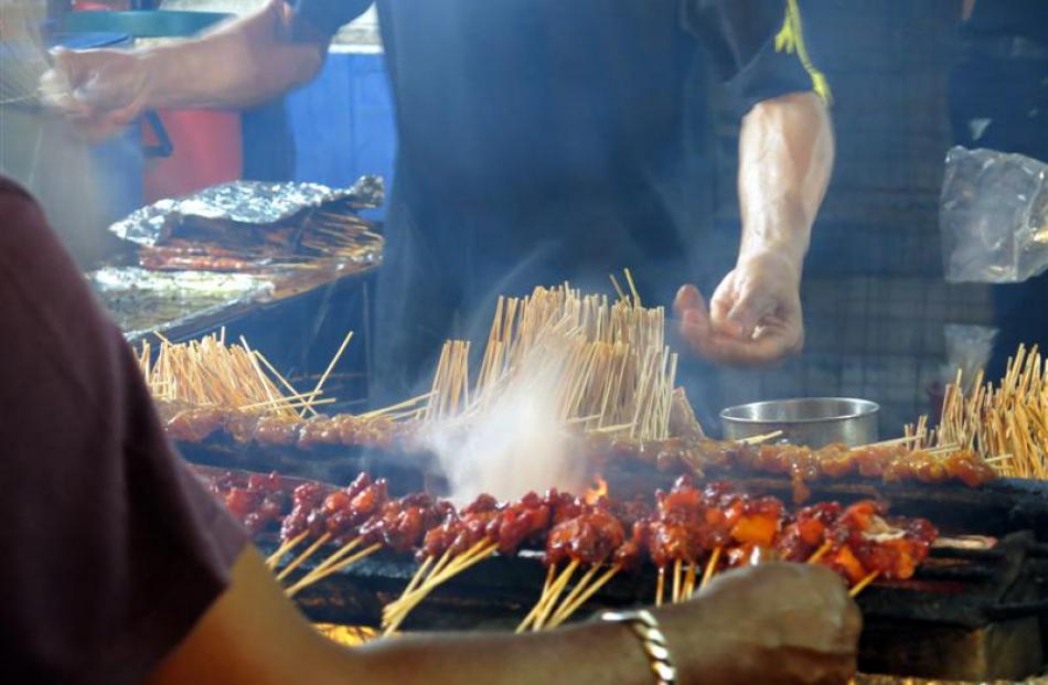 The masters at work cooking the hundreds of satay sticks sold at the evening street market.