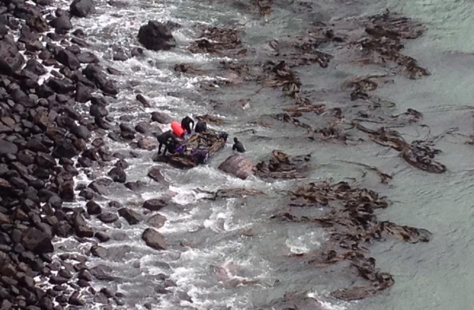 The car is dragged closer to the rocks. Photo by Craig Baxter