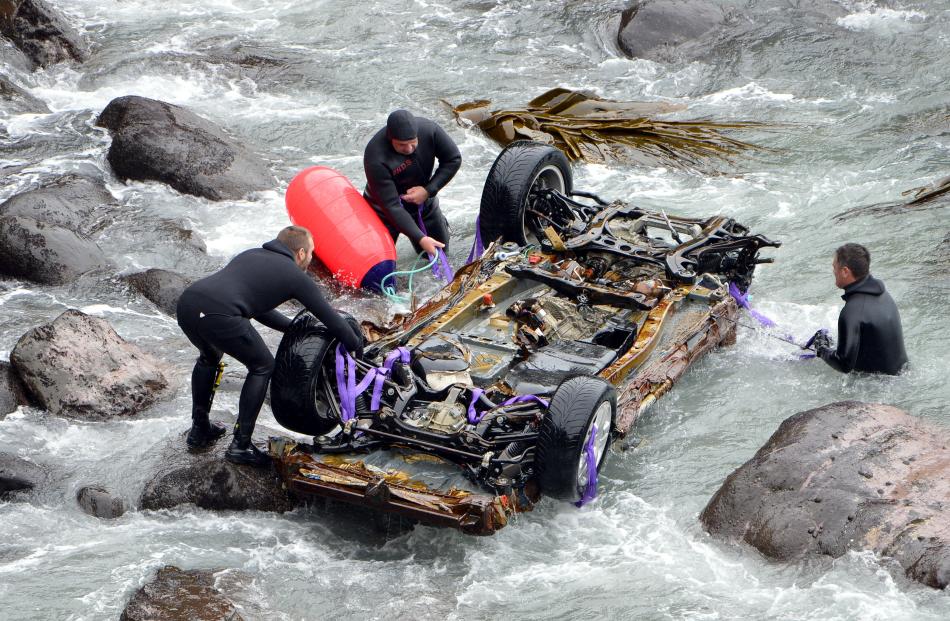 Divers attach buoys  to the car.