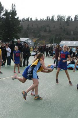 Queenstown Primary School Opals wing defence Pippa Reid (12) tries to wrestle the ball from...
