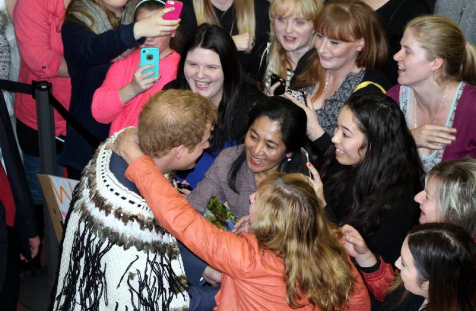 Prince Harry greets the crowd at Invercargill Airport as   Yvonne Gawn, of Invercargill, steals a...