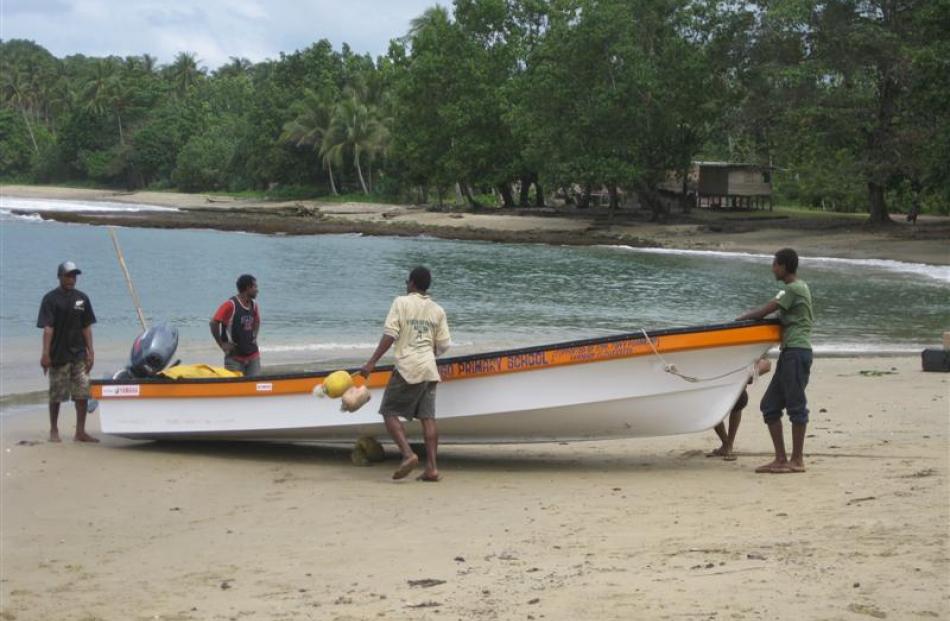 Villagers bring in a boat.