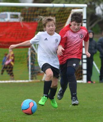 Ethan Zewald (Roslyn Rustlers) at left and George Campbell (Harbourside 10s) contest the ball.