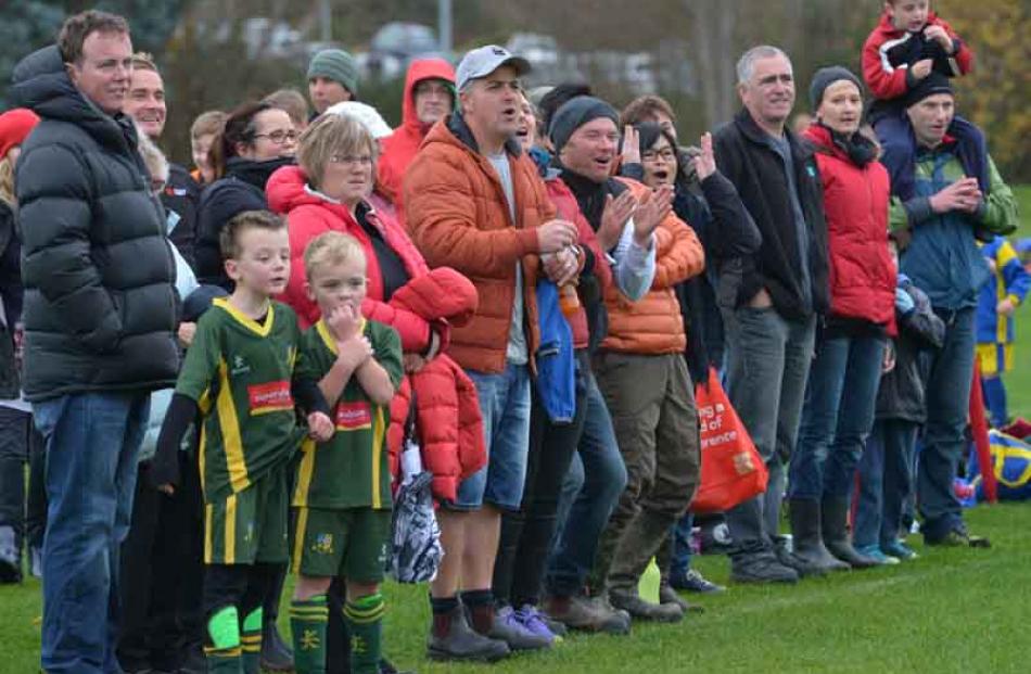 Parents and supporters follow the action from the sideline yesterday.