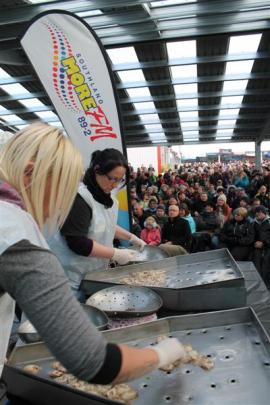 An oyster grader and counter works during the oyster opening competition under the watchful eyes...