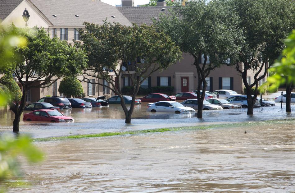 Flood waters cover cars at an apartment complex in Houston. Photo by Reuters