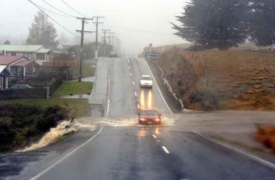 Frasers Creek floods across Dalziel Rd near Brockville.