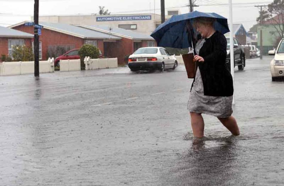 Westpac worker Rebecca Ryan wades home along McBride street after water threatened to affect...