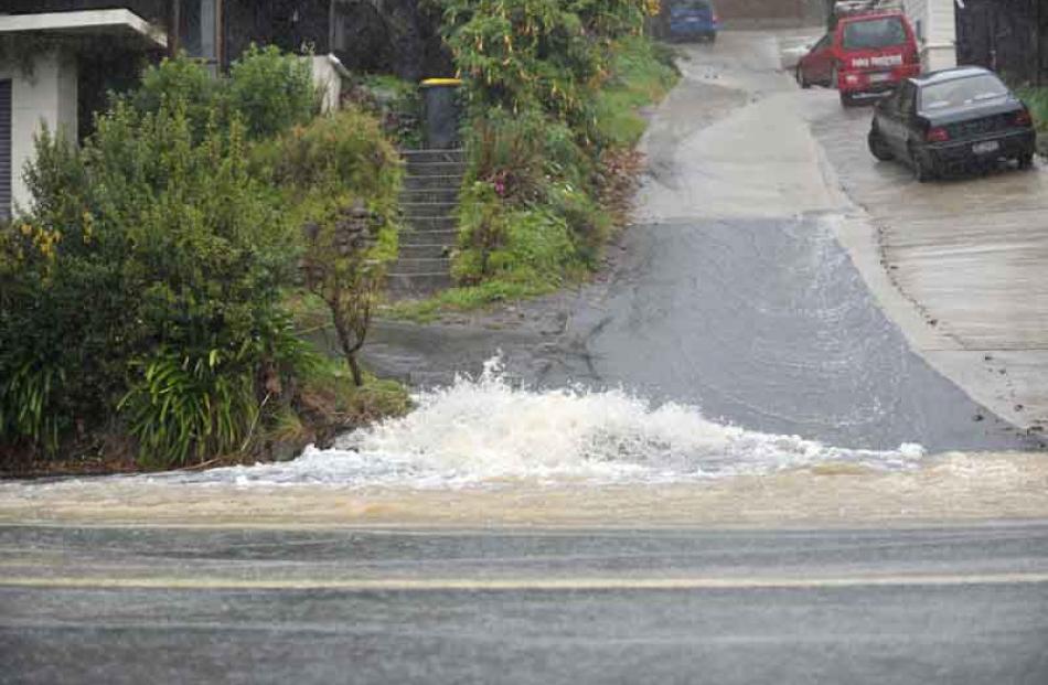 Water pours down a Forbury Rd driveway.