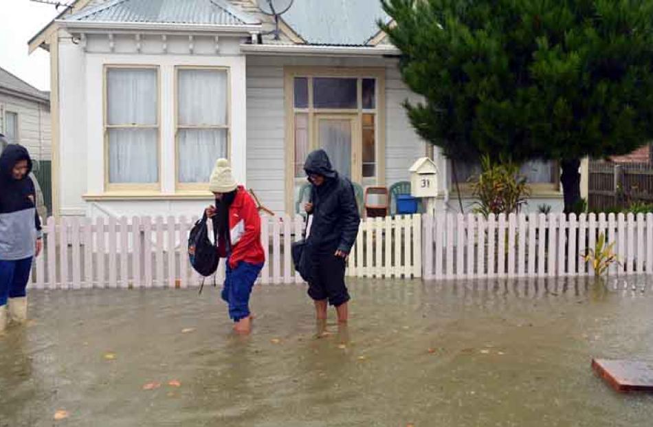 Darcel, Chantelle and Felix Pese evacuate their Nicholson St house as floodwaters rise.