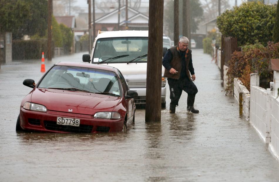 A resident in Nelson St, South Dunedin, heads to check flooding at his property.PHOTO: STEPHEN...