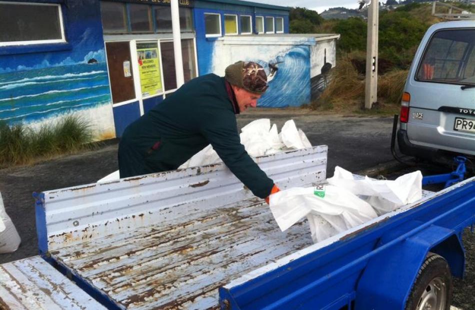 Graeme Gibson unloads sandbags at the St Kilda Surf Lifesaving Club this morning. Mr Gibson was...