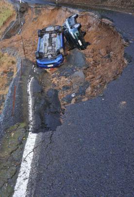 Cars lie in a slip on Highcliff Rd
