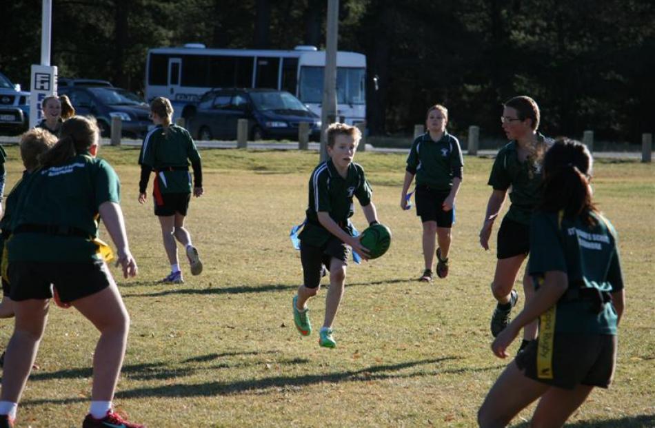 Year 7-8 Terrace Tuis player Kaedyn Laplanche (11) runs the ball through a gauntlet, supported by...