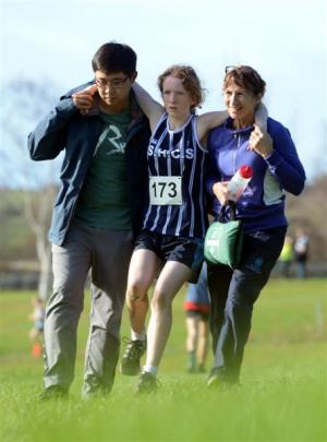 St Hilda's pupil Lily Davis (13) is helped by Tim Li and Trish Conrad after she picked up an injury.