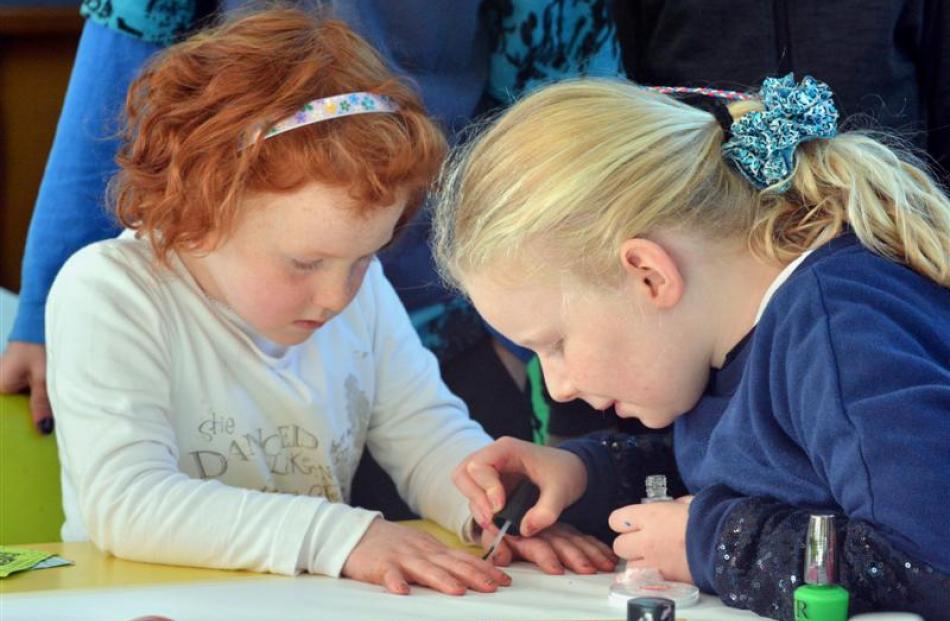 Laura Allison (8) practises painting the nails of Kate McEachen (5) in preparation for the market...