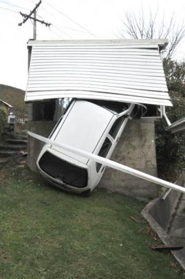 A vehicle hangs precariously from a  garage after crashing through its back wall in Normanby,...