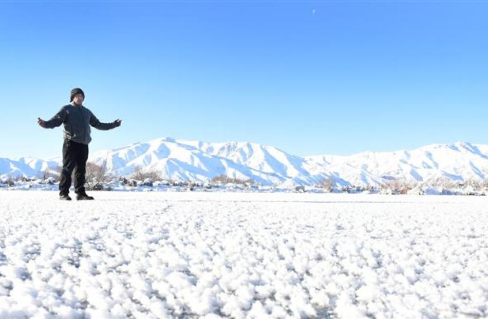 Hot Tubs Omarama owner Lance Thomas walks across a frozen pond at the complex which has been...