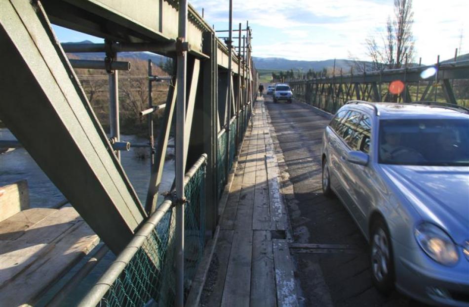 Permanent scaffolding conceals wrought iron trusses on the Beaumont Bridge. The single-lane...