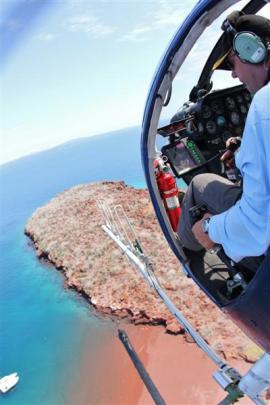 Mr Oakes sowing bait on Bartolome, a volcanic islet in the Galapagos Islands group.