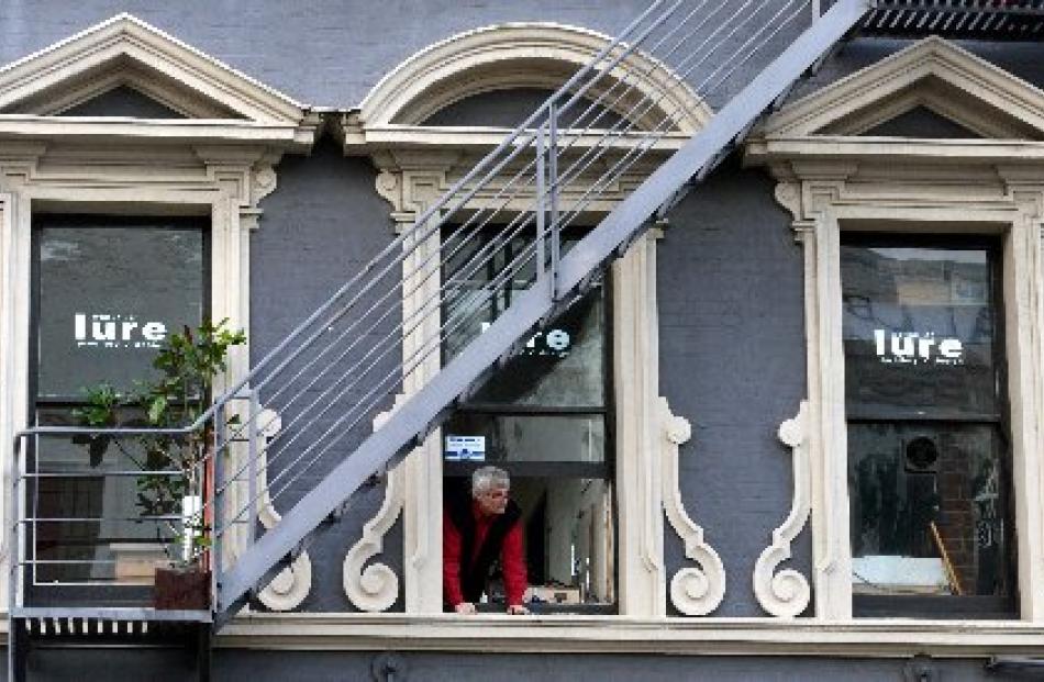 A man looks out from a Lower Stuart St store after power was cut to the area about 2.30 this...