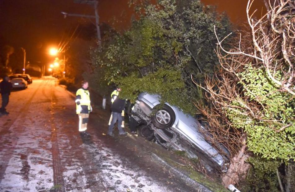 A car is wedged between two trees just metres from a 30m drop in Dunedin's Maryhill Tce about...