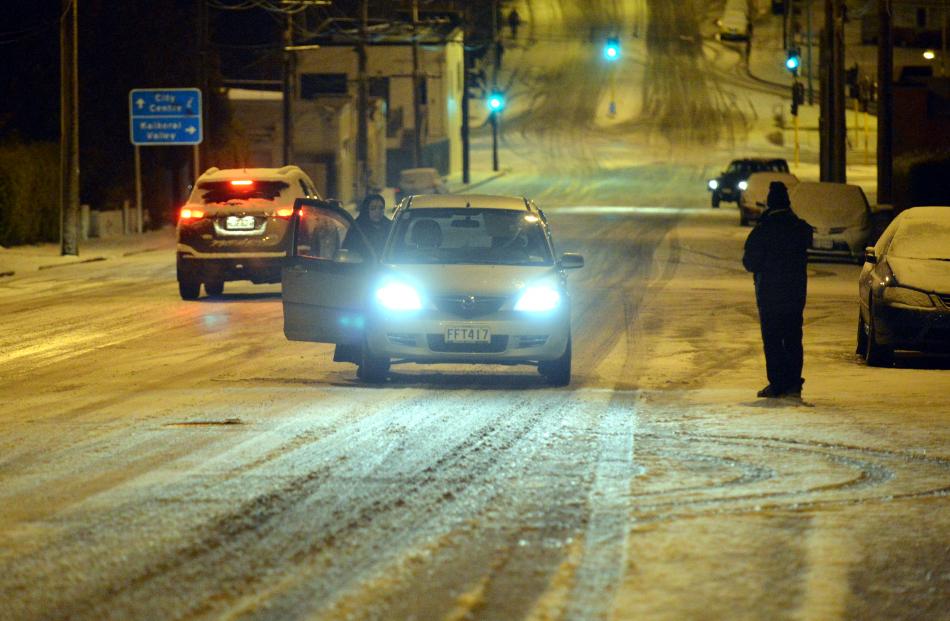 A motorist appeals for help after losing traction on Taieri Rd yesterday morning. Photo by Gerard...