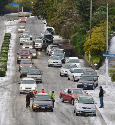 Onlookers help push a car that lost traction on Stuart St in central Dunedin yesterday morning....