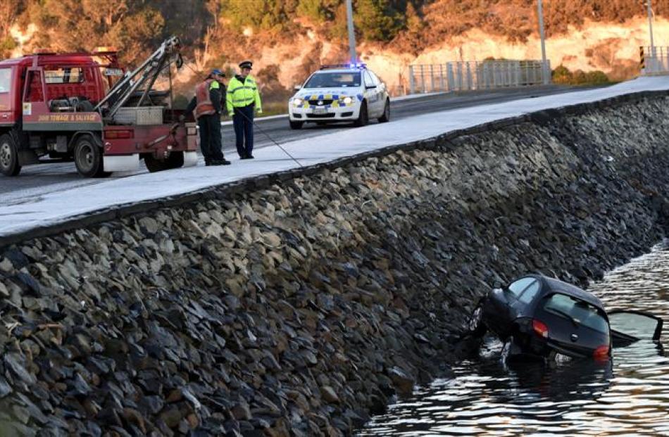 A tow truck  pulls a car out of Otago Harbour yesterday.