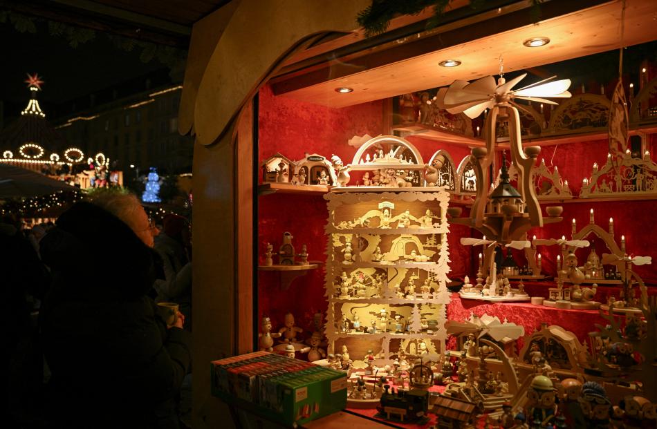 A visitor stands next to a stall at the Striezelmarkt Christmas market on its opening day in...