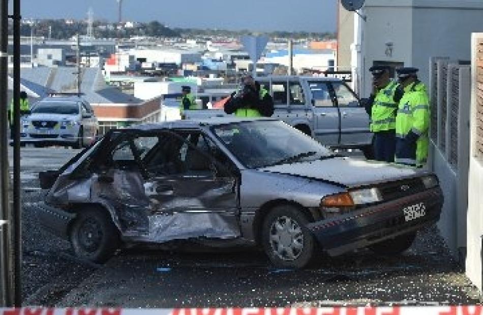 Police examining the crashed Laser this morning. Photo Peter McIntosh