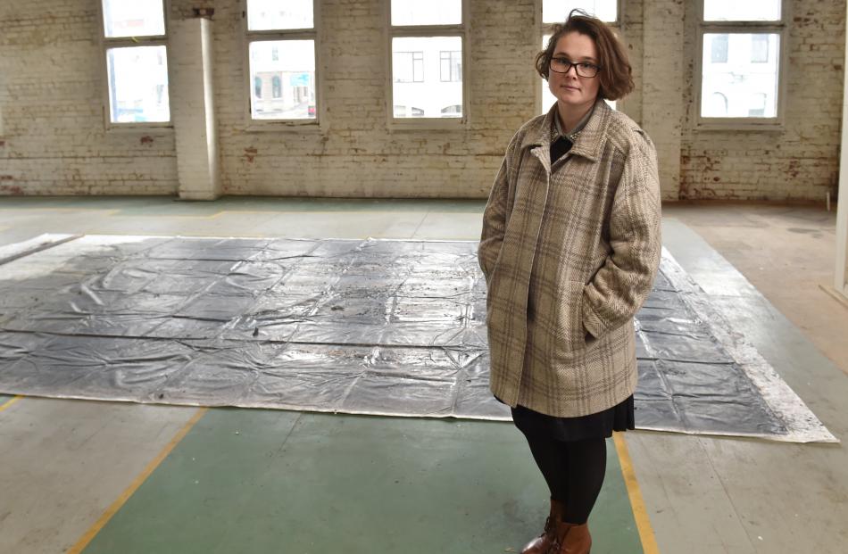 Chloe Geoghegan contemplates how she will hang artist Cobi Taylor's oversize painting. PHOTOS:...