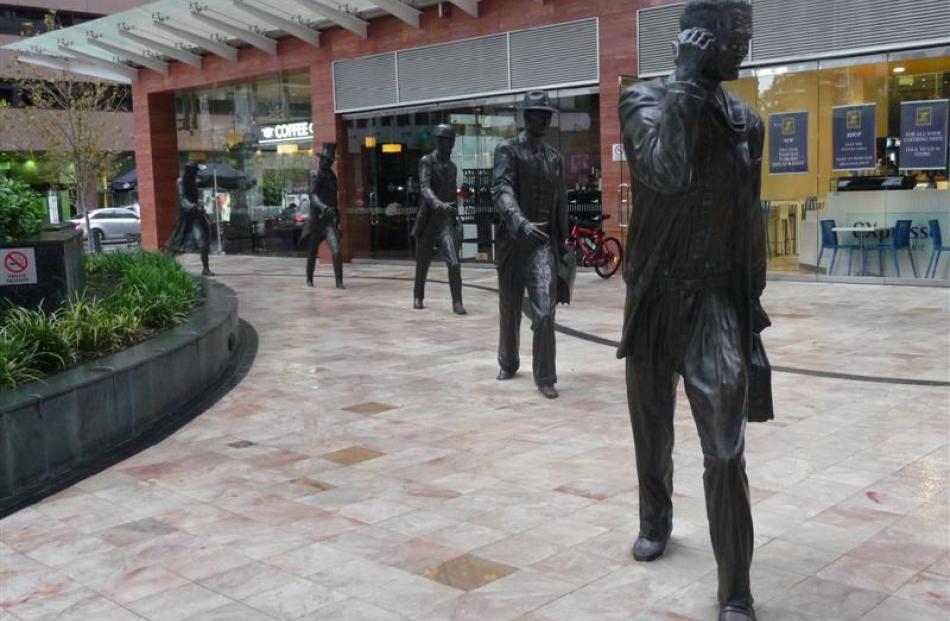 Businessmen walk through the ages in Perth's business district in these sculptures by Charles...