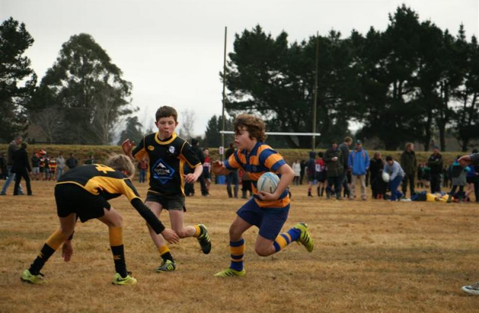 From left, U11 Upper Clutha Gold's Louis Gardner (10) and Ewan Hughes (10) try to stop U11 Toko's...