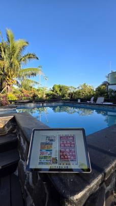Kim Barnes, of Fairfield, keeps up with the news back home on Christmas Day in Rarotonga. PHOTO:...