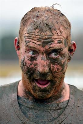 Luke Van Oosten (30), of Wanaka, attempts to clear his eyes of mud.