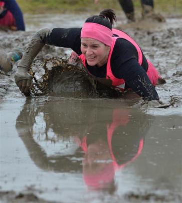 Tasha Clay (33), of Invercargill, drags herself through one of the obstacles in the Mud, Sweat...