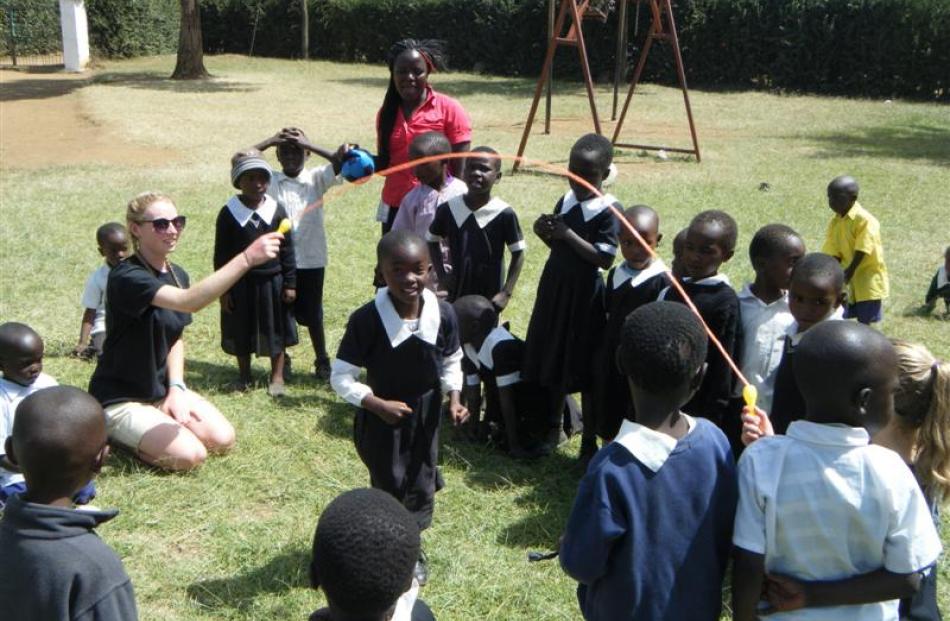 Taieri College pupils Kristen Hackfath and Ashleigh Hammer play with  children at Njoro School in...