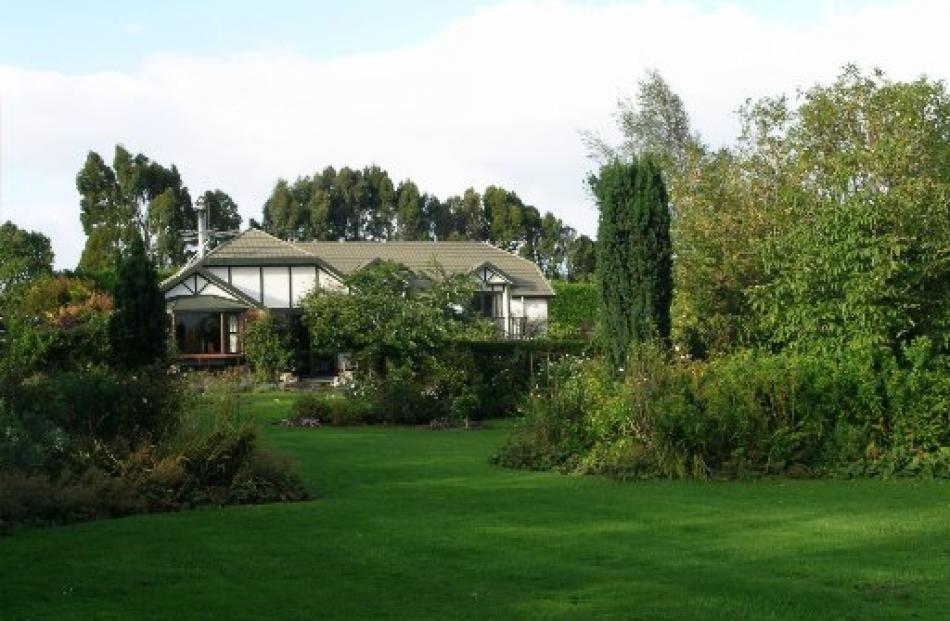 A broad lawn sweeps through the main part of the garden at Tudor Park.