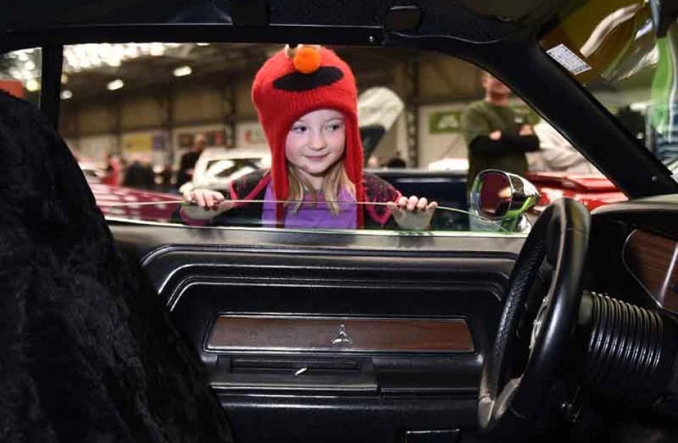 Kamyn Hale (8), of Brighton takes a peak at Terry and Kerry Martin's Dodge Challenger.