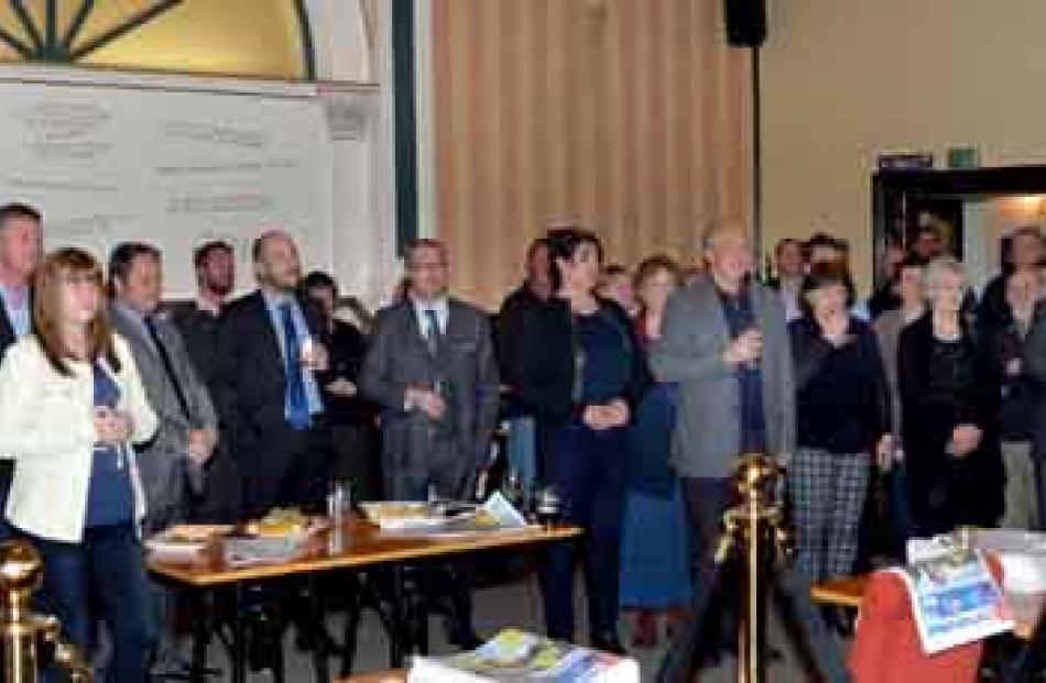 Guests and newspaper staff listen to a speech by Waitaki Mayor Gary Kircher.