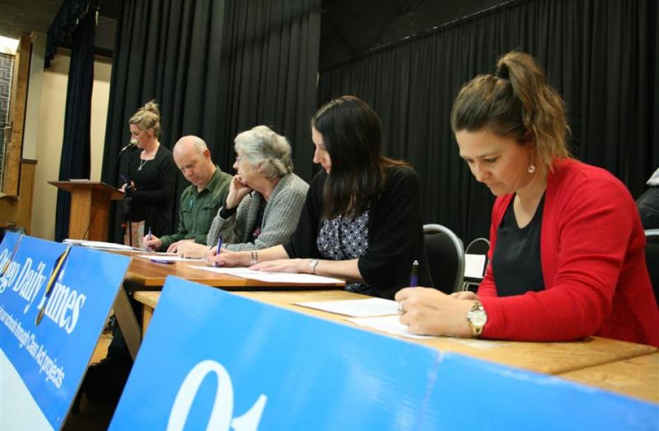 Quiz master Tineke Hayes, of Dunstan High School, reads out questions as teachers (from left) ...